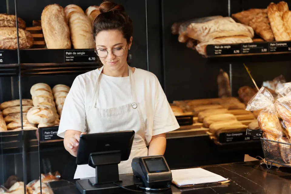 Gérante de boulangerie devant sa caisse
