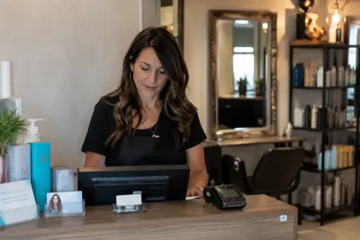 Gérante de salon devant sa caisse